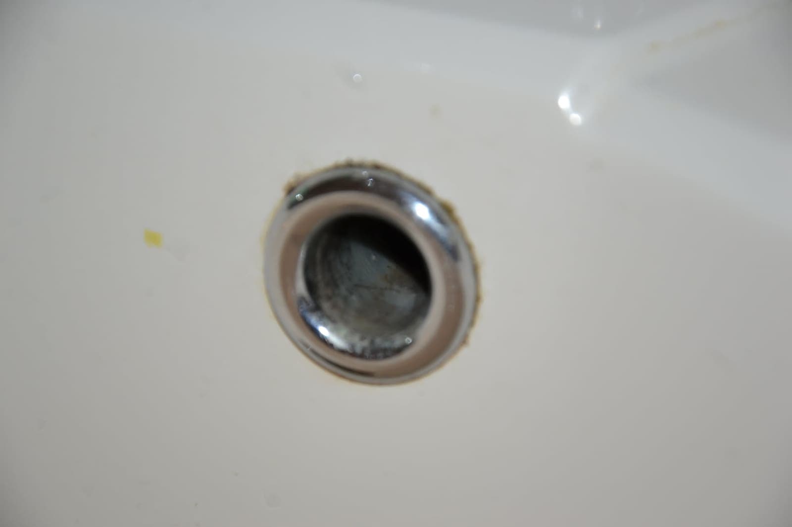 Bathroom basin drain scrubbed clean — Before